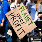 Students protesting with a banner "Planet over profit"