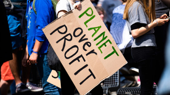Students protesting with a banner "Planet over profit"