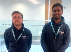 Two smiling students wearing LJMU hoodies and lanyards.